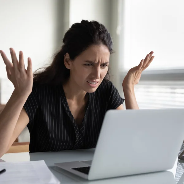 Une femme assise à un bureau, les mains tendues, évoquant une offre de prêt d'argent sans refus.