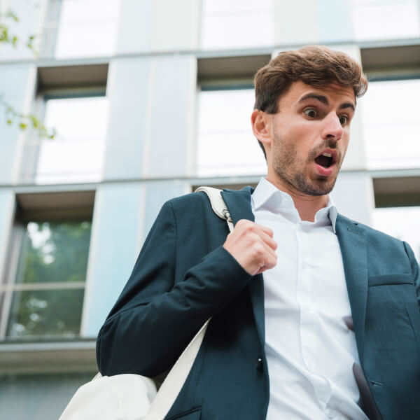 A man in a suit holding a cell phone, possibly discussing financing options for potential clients.